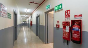 Fire extinguisher and emergency exit sign inside a labour camp in Sharjah Industrial Area